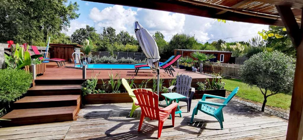 a group of chairs and an umbrella on a deck at MAISON &amp; PISCINE PRIVES,PLAGES OCEAN ET LAC A 10 kms in Linxe