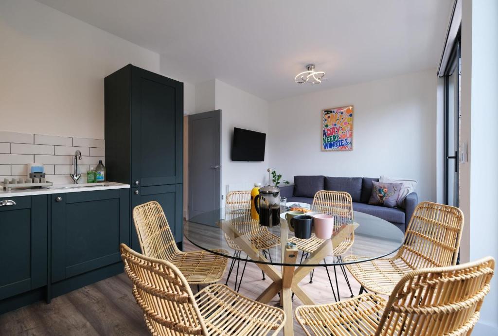 uma sala de estar com uma mesa e cadeiras e um sofá em Stunning Acton Apartment With Balcony em Londres