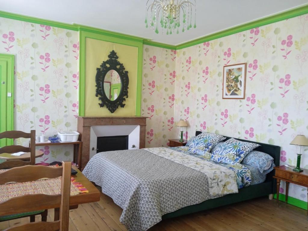 1 dormitorio con cama y lámpara de araña en Chambres d'hôtes les Clématites en Cotentin, en Saint-Floxel