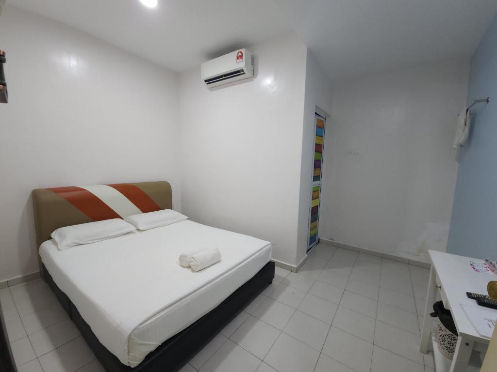 um pequeno quarto branco com uma cama e um aquecedor em Minshu RoomStay em Arau