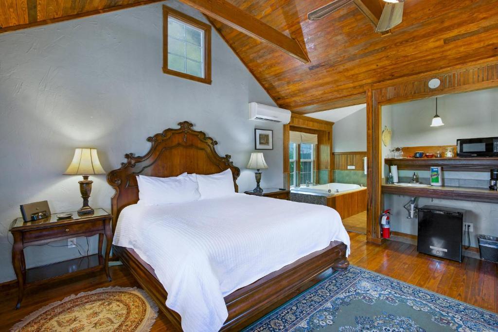 a bedroom with a large bed and a fireplace at Swing On Inn- Rockin Boots Cottage in Dripping Springs