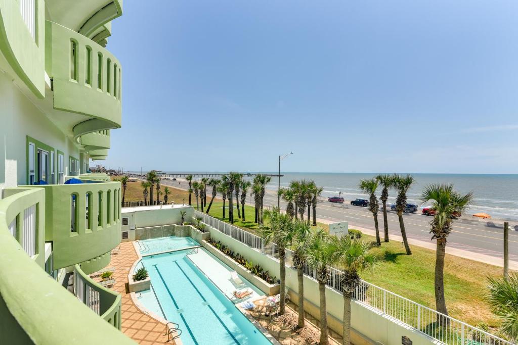 a view of the pool and beach from the balcony of a building at Oceanfront Galveston Condo in Amazing Location! in Galveston
