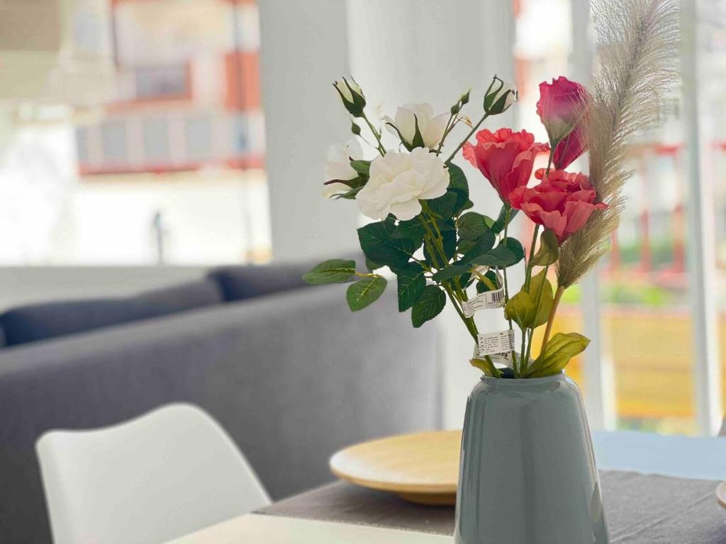 un vaso pieno di fiori seduto su un tavolo di Apartamento cerca de la playa, Torre Del Mar a Torre del Mar