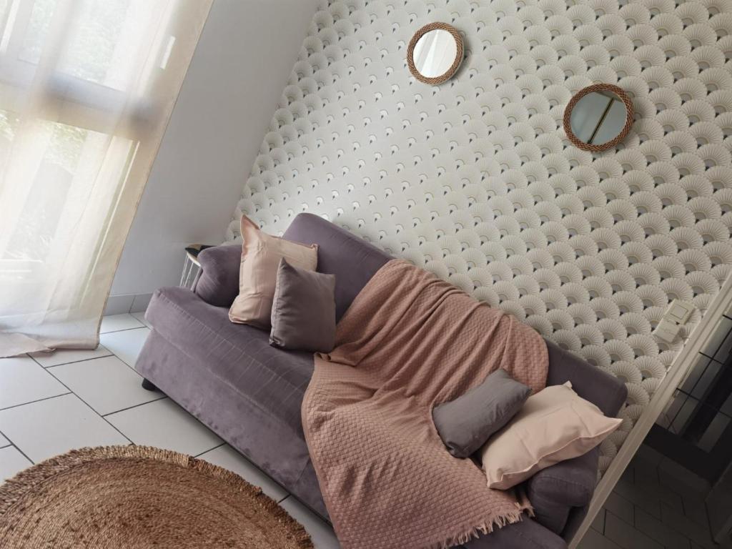 - un canapé avec des oreillers dans le salon dans l'établissement Agréable T1 bis en bord de Loire, à Blois
