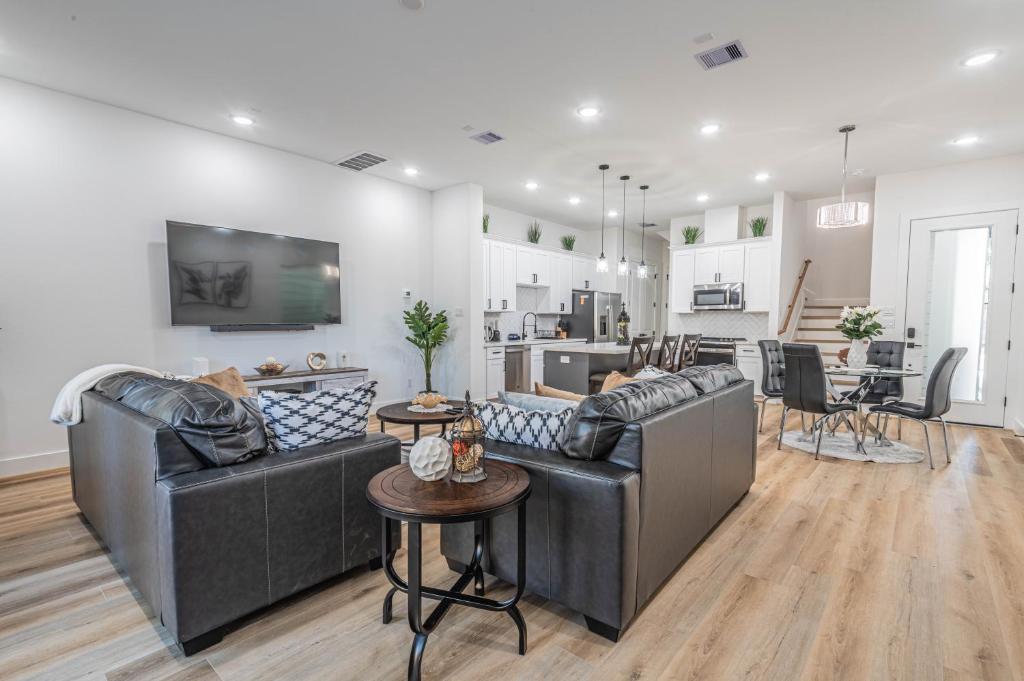 un salon avec deux canapés en cuir et une cuisine dans l'établissement New! Houston Luxury Haven near Dwtn, Med CTR, à Houston