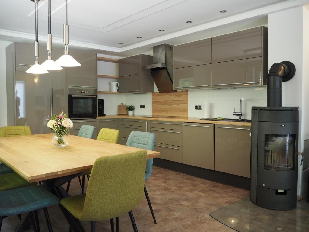 a kitchen with a wooden table with chairs and a fireplace at Haus Sonnenschein in Klagenfurt