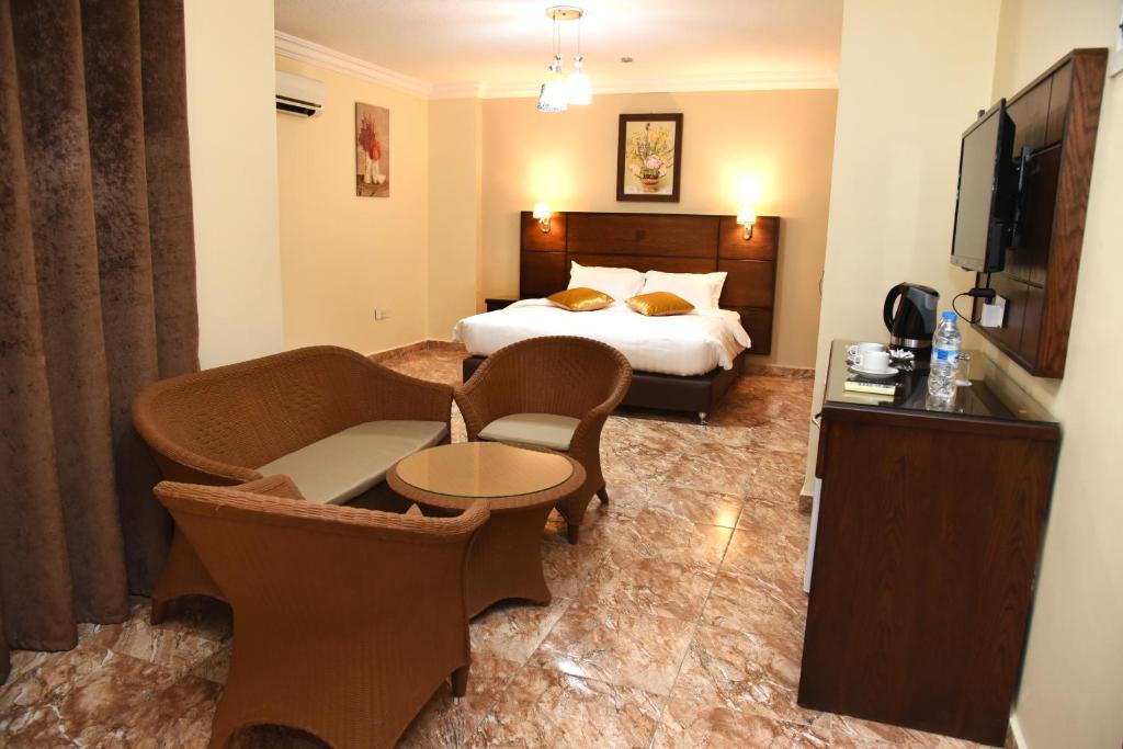 pokój hotelowy z łóżkiem, stołem i krzesłami w obiekcie Karam Inn w Akabie