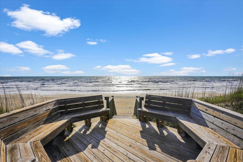 dwie ławki siedzące na promenadzie na plaży w obiekcie Whalehead Watch w mieście Corolla