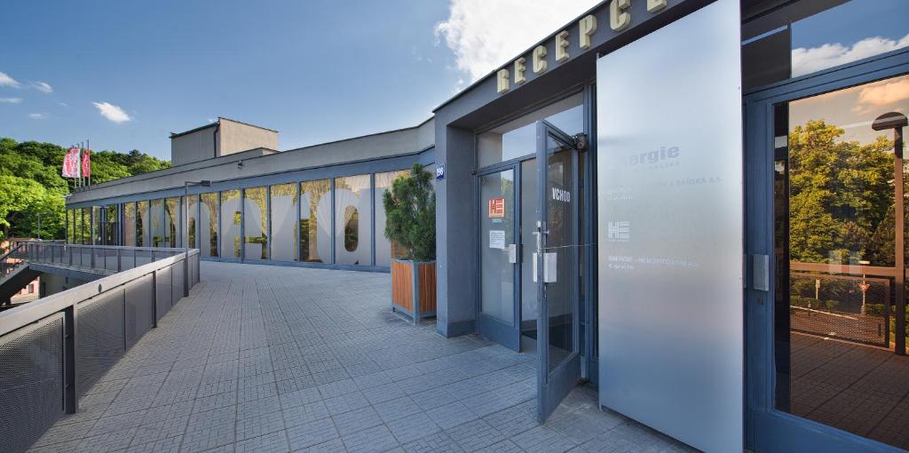 a building with glass doors and a walkway at Hotel Energie in Prague