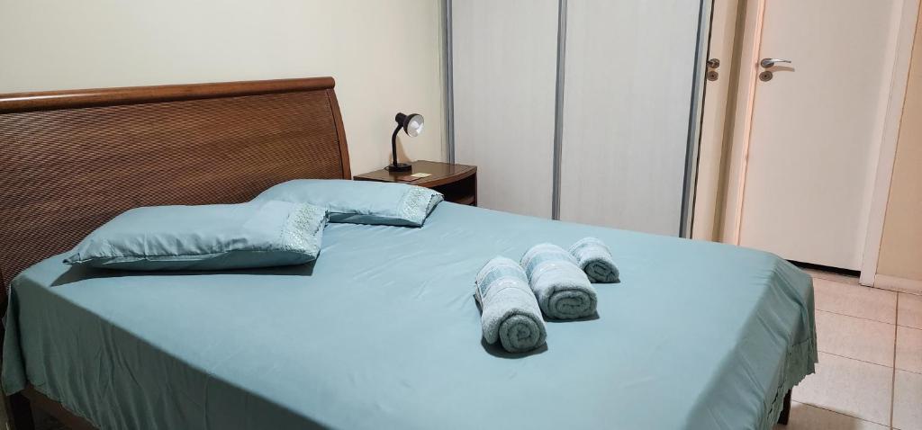 a bed with blue sheets and towels on it at Apartamento por temporada RJ próximo ao Riocentro, Parque Olímpico e Jeunesse Arena in Rio de Janeiro