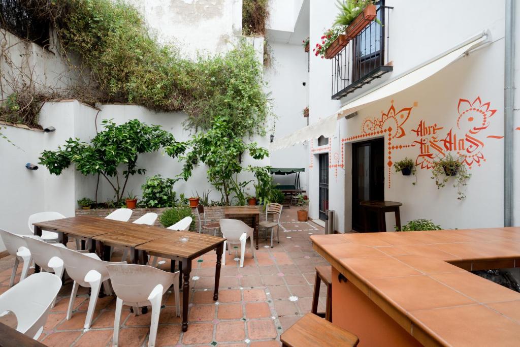 un patio al aire libre con mesas, sillas y plantas en Oasis Backpackers' Hostel Granada, en Granada