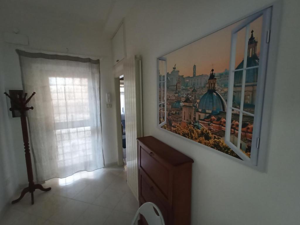 una camera con un dipinto sul muro e una finestra di Appartamento Stella Polare a Lido di Ostia