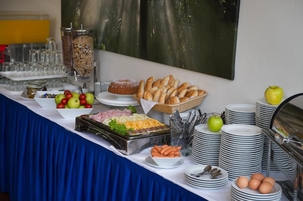 a table with food and plates of food on it at Hotel Energie in Prague