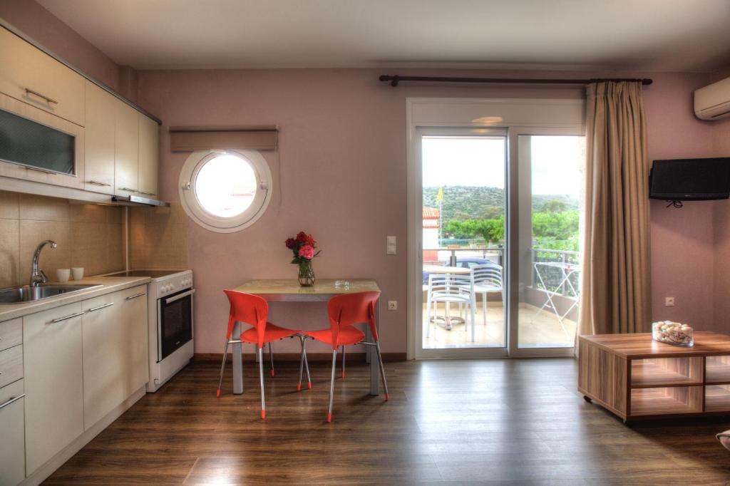 cocina con mesa y sillas y balcón en Apanema Apartments, en Vivari