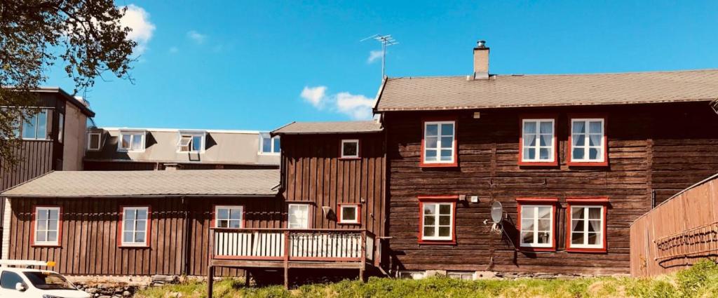 a large wooden house with a balcony in front of it at Nedre Stensgården in Røros