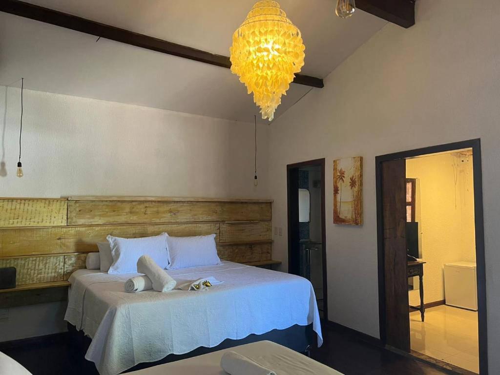 a bedroom with a bed and a chandelier at Pousada Coral Negro in Jericoacoara