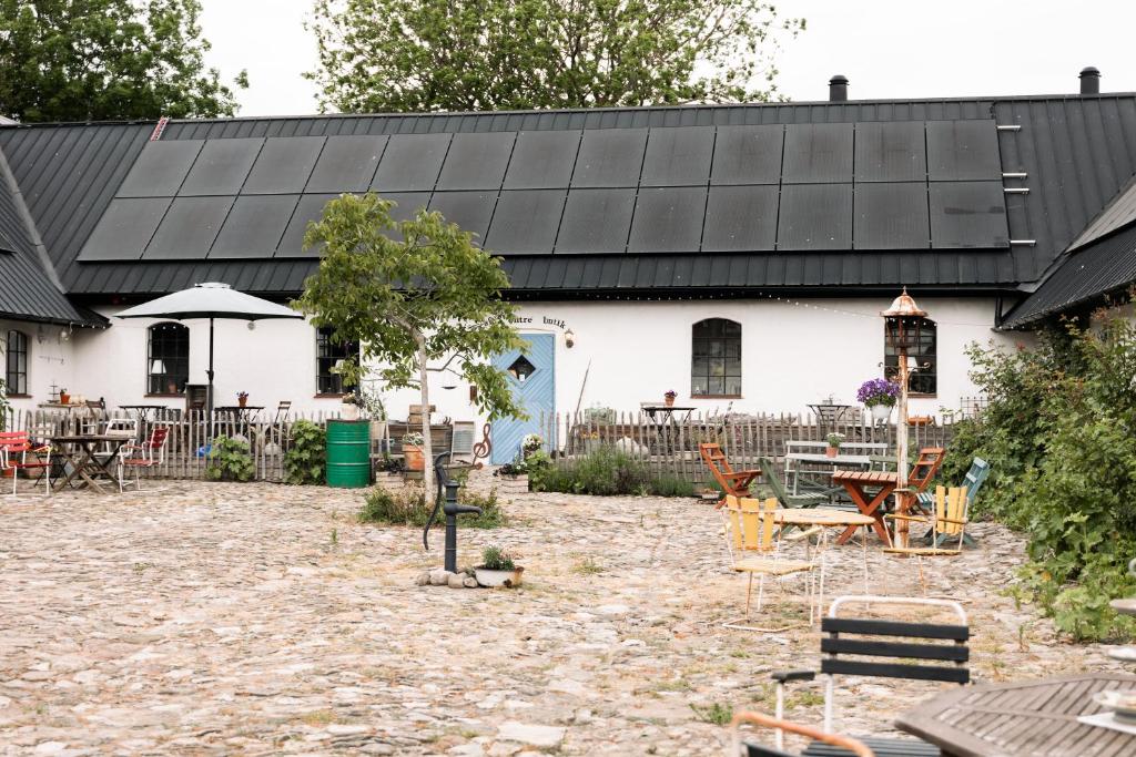 ein weißes Gebäude mit schwarzem Dach in der Unterkunft Sköllengården in Simrishamn