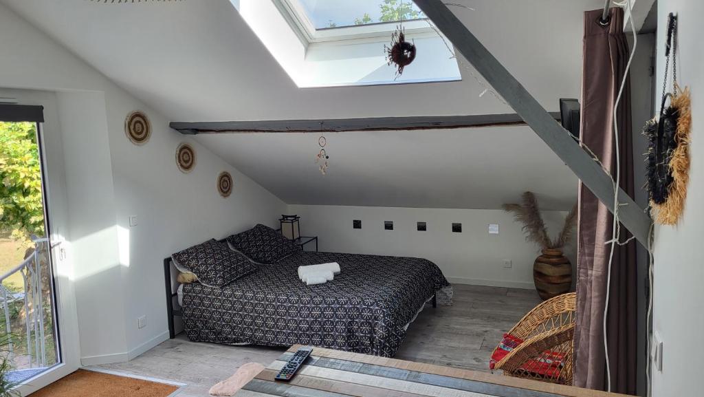 1 dormitorio en el ático con cama y ventana en PROMISE' LANDES en Saint-Paul-lès-Dax