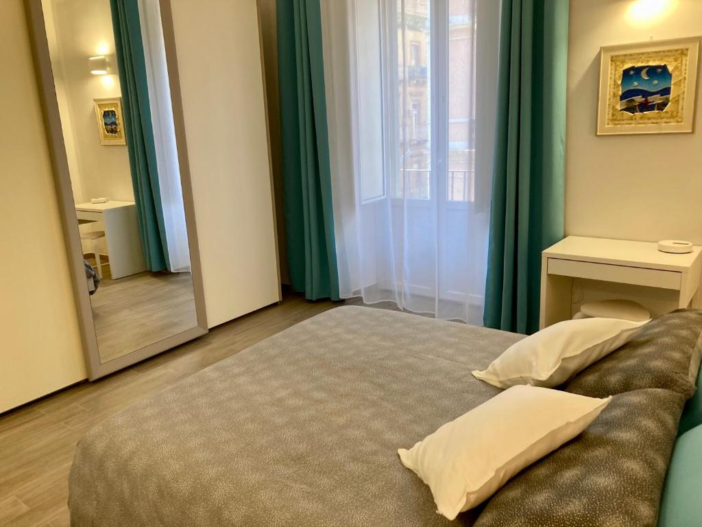 a bedroom with a bed and a couch and a window at Casa Semplice in Taranto