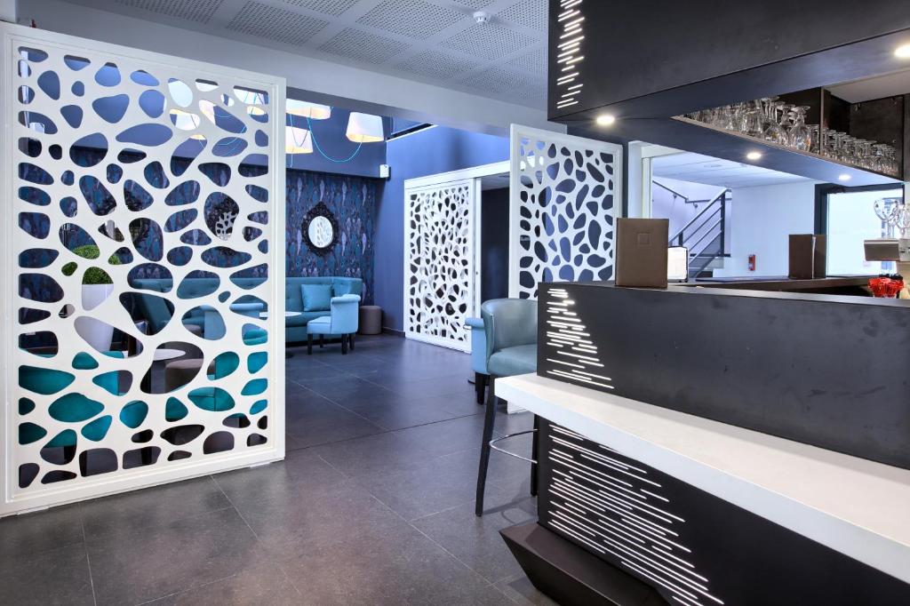 a lobby with a bar with blue and white accents at Au Comté d&#39;Ornon Hôtel &amp; Spa in Gradignan