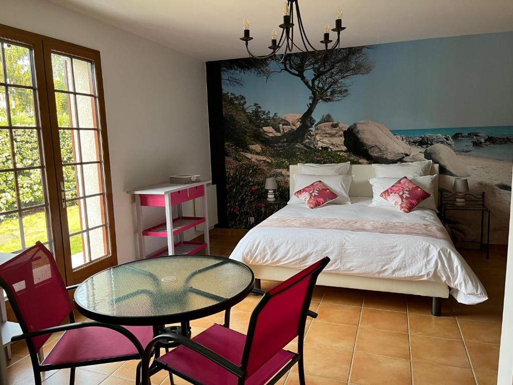 una camera con letto, tavolo e sedie di Ô Mélèze a Morsang-sur-Orge