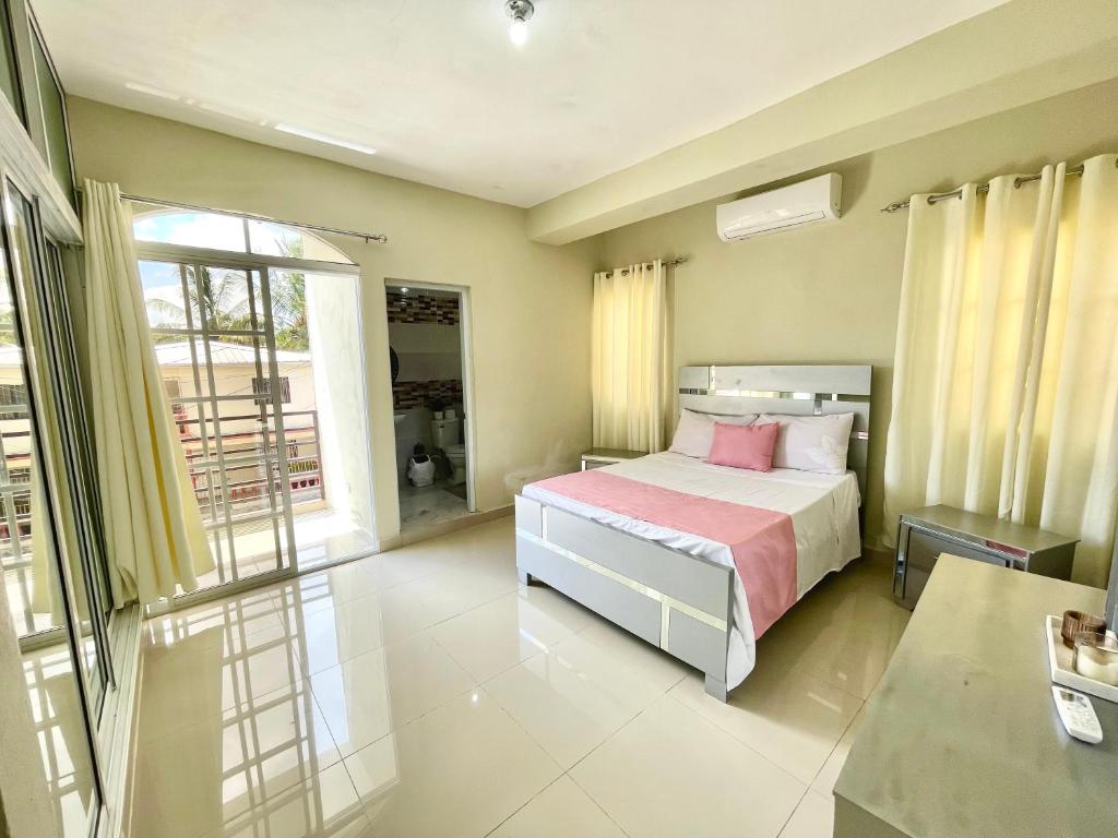 um quarto com uma cama e uma grande janela em Balcón Skyline 2 em Jarabacoa