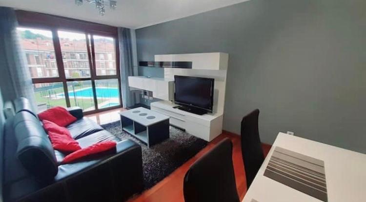 ein Wohnzimmer mit einem Sofa und einem TV in der Unterkunft Chuchi house in Ramales de la Victoria