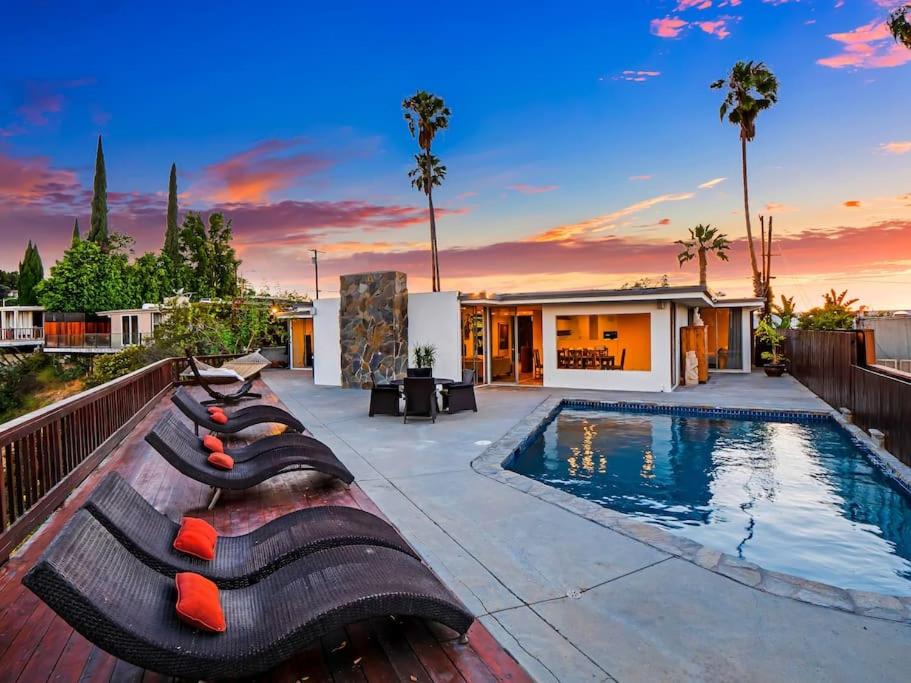uma piscina com espreguiçadeiras ao lado de uma casa em MULHOLLAND HILLS RETREAT W/BEST VIEWS IN LA em Los Angeles