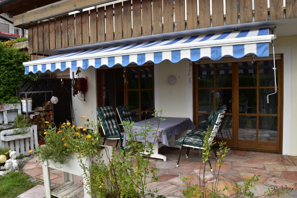 un patio con mesa y sillas frente a una casa en 2 Zi. Wohnung fürs Wandern, Baden, Ski & die Wiesn, en Wolfratshausen