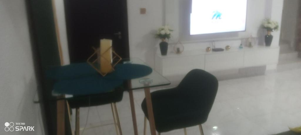 een keuken met een tafel en twee blauwe stoelen bij George's property in Accra