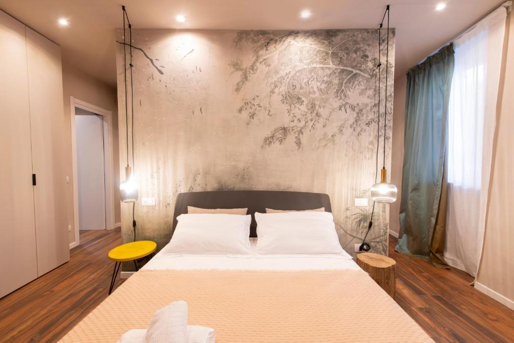 Un dormitorio con una cama grande y una pared en San Benedetto Rooms, en Crema