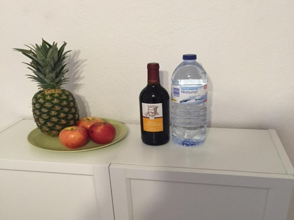 una botella de vino y un plato de fruta y una botella de agua. en Apartamento Bairro Alto, en Lisboa