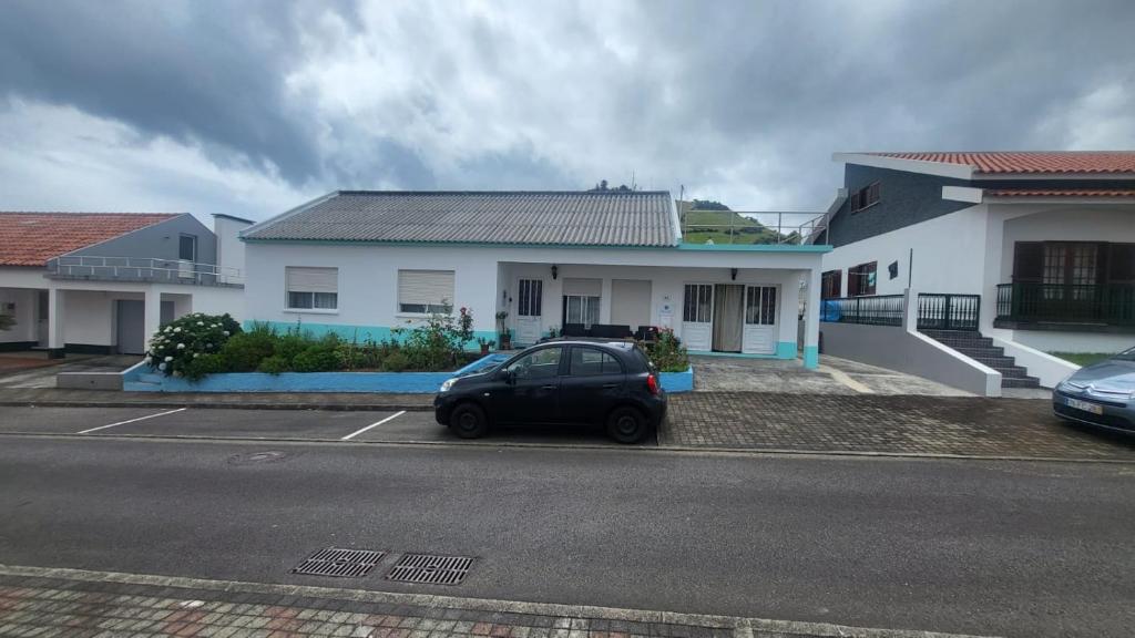 a car parked in a parking lot in front of a house at Dona Julia in Santa Cruz das Flores