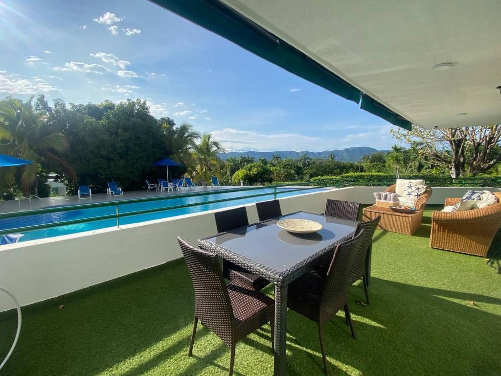 a patio with a table and chairs next to a swimming pool at Apartamento en el penon 5 alcobas 7 baños in Girardot