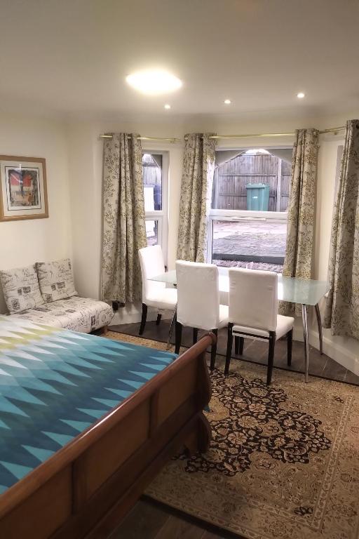 1 dormitorio con 1 cama, mesa y sillas en Leamington Park Studio with Parking, en Londres