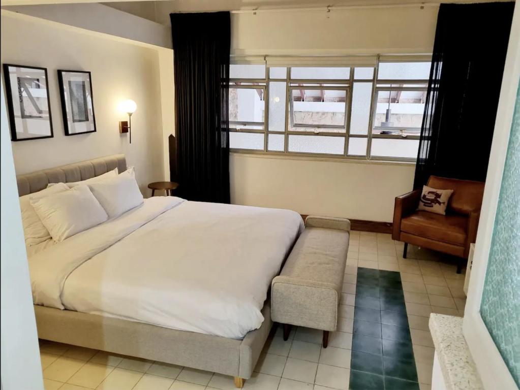 Un dormitorio con una cama y una silla y una ventana. en AmazINN Places Casa Bandera II, en Panamá