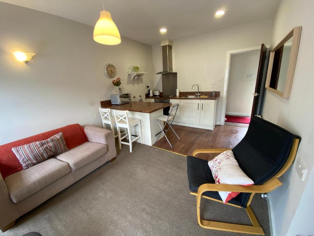 a living room with a couch and a kitchen at Irvinestown Fermanagh 2 Bedroom Apartment in Irvinestown