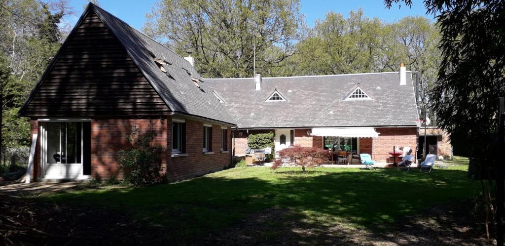 ein Backsteinhaus mit einem Gameradach in der Unterkunft Grande maison au calme au cœur d un bois 11 personnes in Ferrières