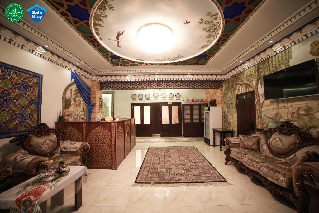 uma sala de estar com sofás e um tecto grande em Мы открылись! Hotel Guli em Bukhara