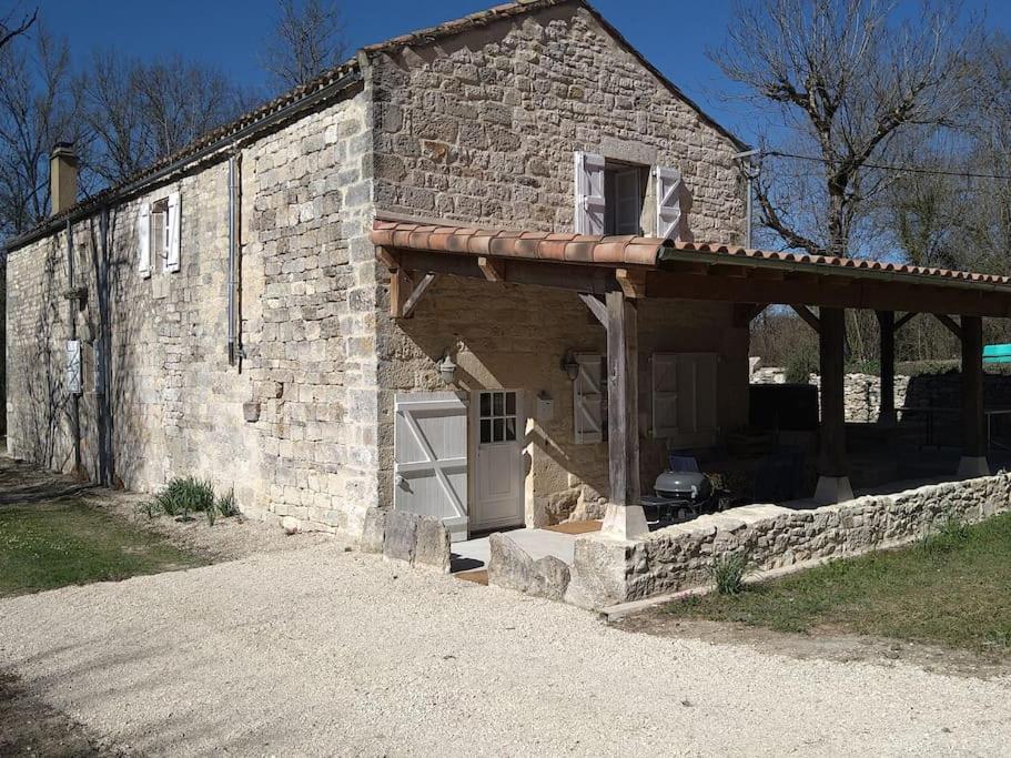 un edificio de piedra con puerta y garaje en Le Moulin de la Borie en Belfort-du-Quercy