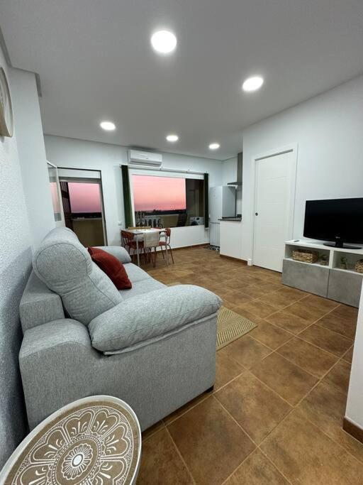 sala de estar con sofá y TV en Apartamento puestas de sol en Chiclana de la Frontera