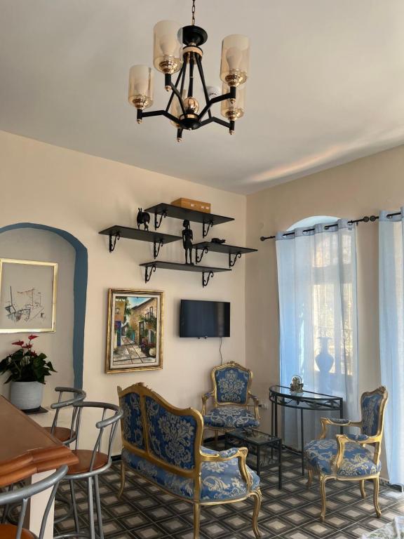 a living room with chairs and a table and a chandelier at La Provençale in Jerusalem