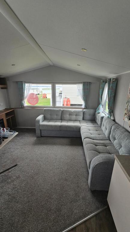 a large living room with a couch and a large window at Haven Kent Coast Allhallows 3 bed in Allhallows