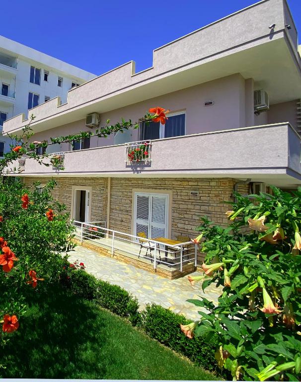 a house with a patio and a balcony with flowers at Aparthotel PAJA Ksamil in Ksamil