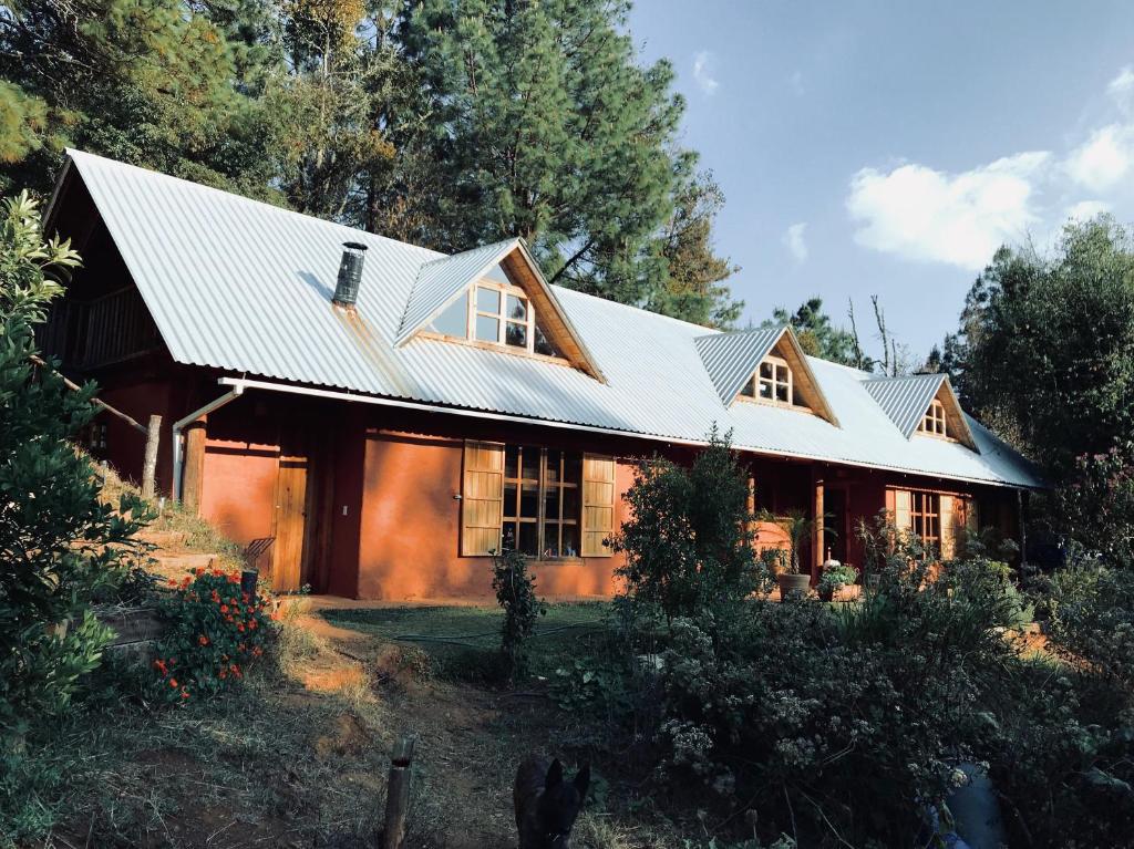 dom z metalowym dachem i drzewami w obiekcie Casa Sierra y Casita Sierra 