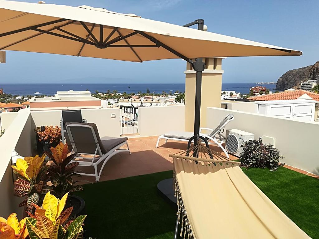 a patio with a large umbrella on a roof at Rooftop Del Mar in Palm-Mar