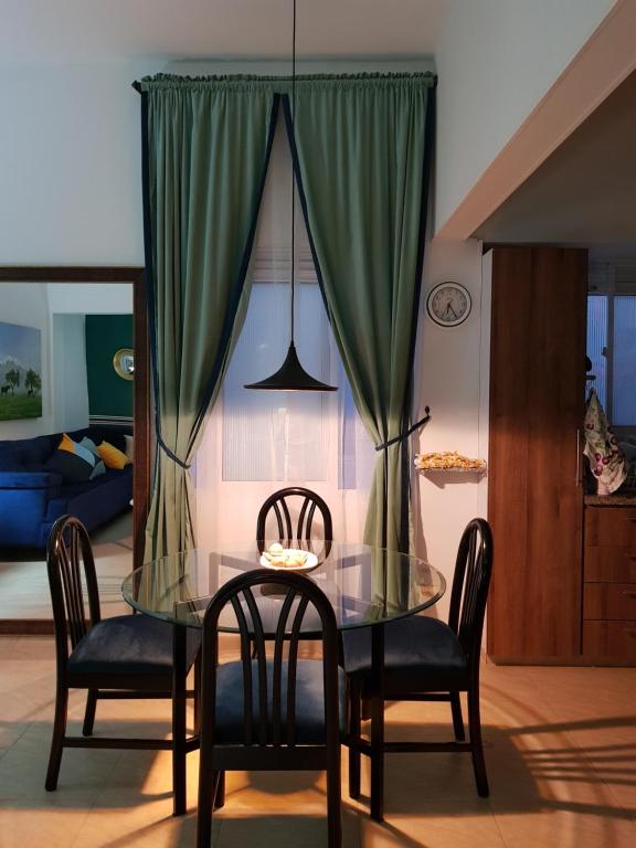 a dining room with a glass table and chairs at Encantador Apartamento in Ibagué