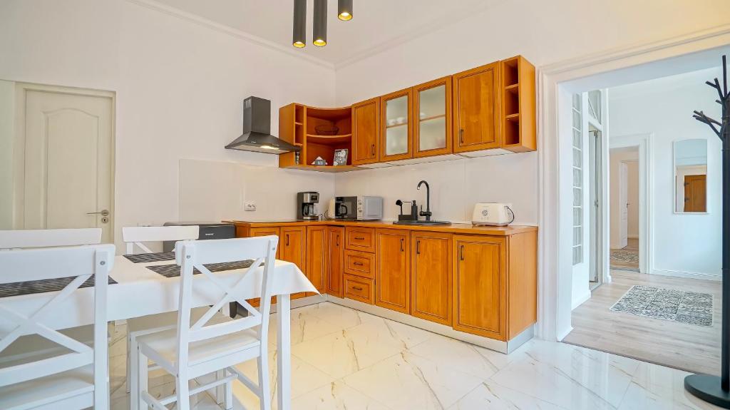 una cocina con armarios de madera y una mesa con sillas. en Comfort Apartment Barițiu Brașov, en Brasov