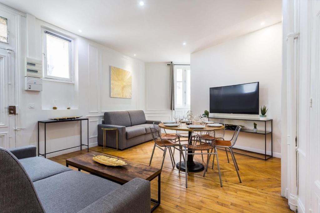 un salon avec une table et une télévision dans l'établissement Appartement accueillant -1BR-6P - Auteuil - Passy, à Paris