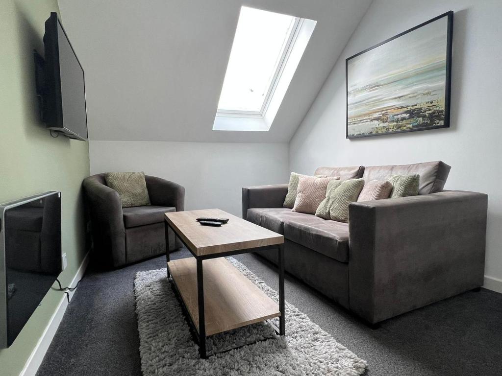 een woonkamer met een bank en een tafel bij Dunbar High Street One Bedroom Apartment in Dunbar